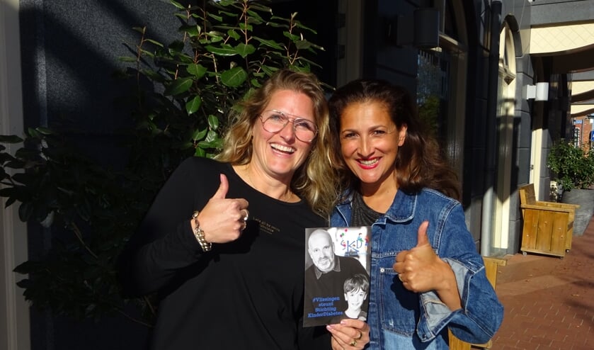 Martine Rademaker en Roxane van den Berg tonen de poster die bij veel Vlissingse winkeliers aan de ramen hangt. FOTO MARIELJA TEN BRUGGENCATE