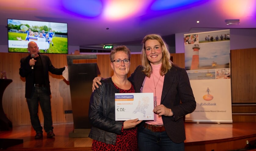 Een lid van KV Stormvogels krijgt de cheque uit handen van Edith Bosch.