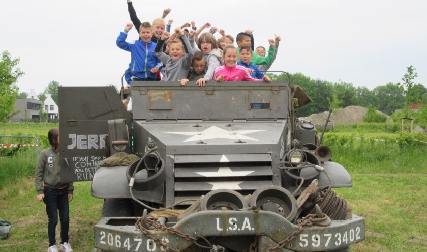Kapelse kinderen bij een legervoertuig van museum Vitality.