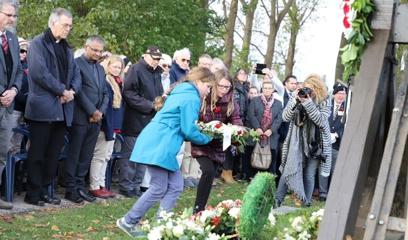 Twee meisjes legden een krans neer bij het monument.