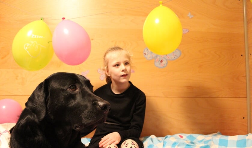 Faye (9) in haar nieuwe bed met haar KNGF buddyhond Guus