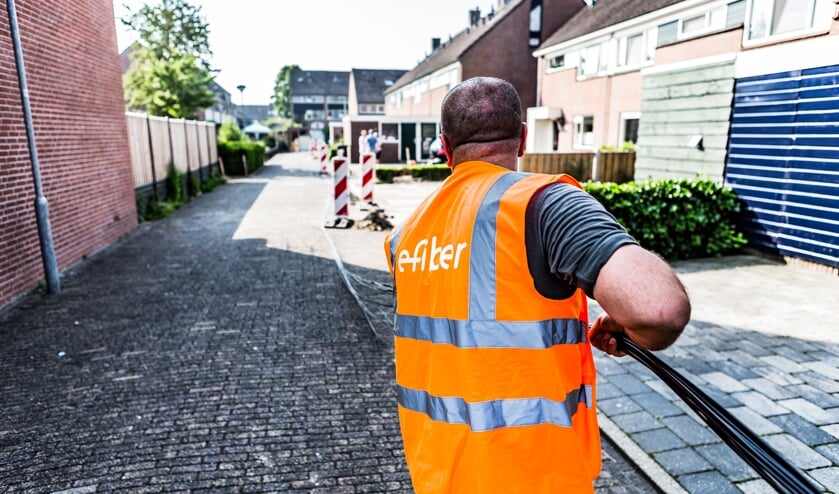 Medewerkers van E-fiber leggen glasvezel aan.
