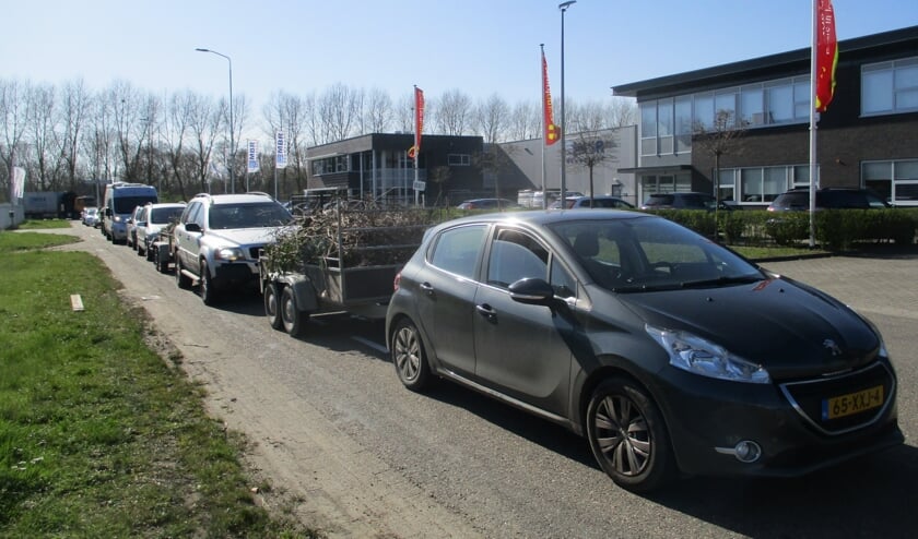 Een lange rij van automobilisten bij de milieustraat.