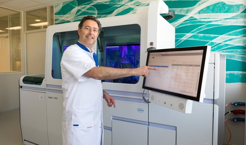 Arts-microbioloog Bram Diederen bij de nieuwe machine waarmee meer en sneller getest kan worden op het coronavirus.