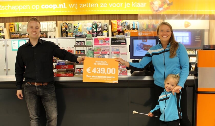 De penningmeester van Re-Creation neemt samen met het jongste lid van Re-Creation een mooi bedrag in ontvangst.