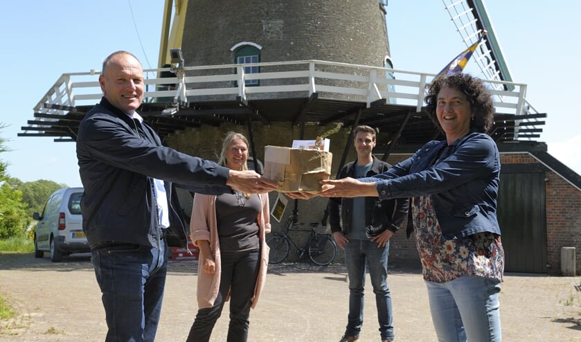 Chris Maas neemt het eerste pakketje in ontvangst uit handen van de initiatiefnemers.