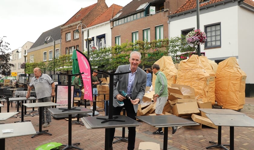 Wethouder Willy Knop steekt een handje toe bij de bouw van het megaterras op de Markt in Steenbergen.
