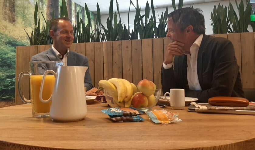 Reggy Heijens (rechts) aan de keukentafel met Luuk Roozeboom.