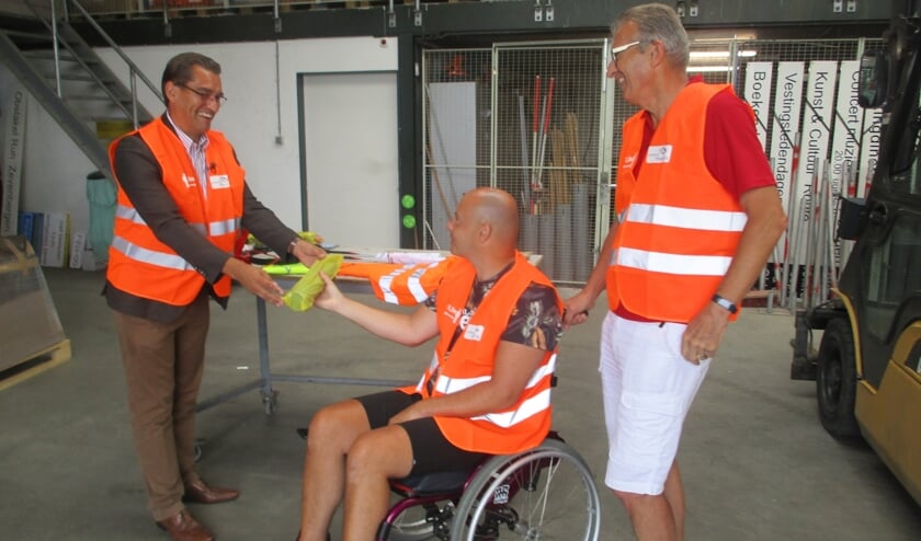 Marijn Koevermans ontvangt van wethouder Van Dorst de spullen die hem moeten helpen bij het weghalen van zwerfvuil.