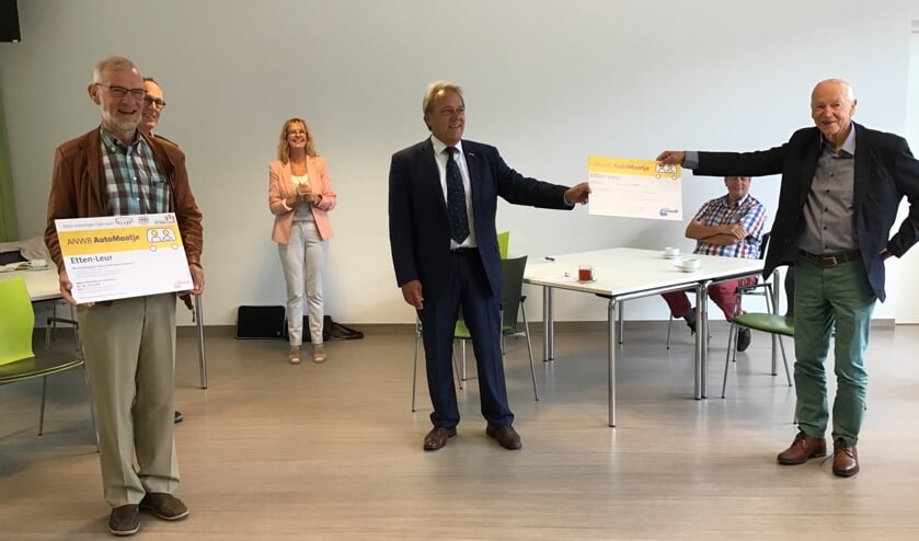 De uitreiking van de vrijwilligerspas aan chauffeur Jaap Visser en deelnemerspas aan Peter Berting.