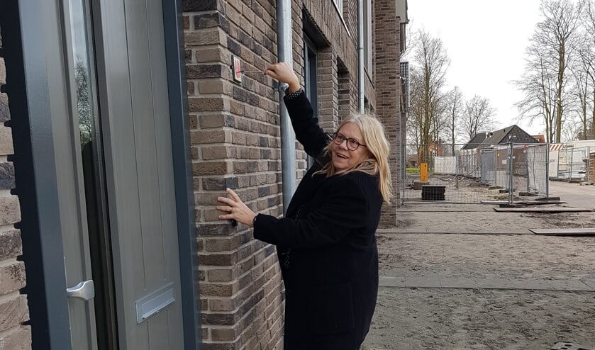 <p>Wethouder Wilma Baartmans bevestigt een klaproosschildje aan het eerste huis aan de Piet Snoeijersstraat.</p>