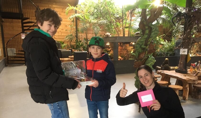 Wessel Enning (L) en Jan Dammer hebben geld opgehaald voor het reptielenhuis De Aarde en overhandigen dat aan Tessa Groenendaal.
