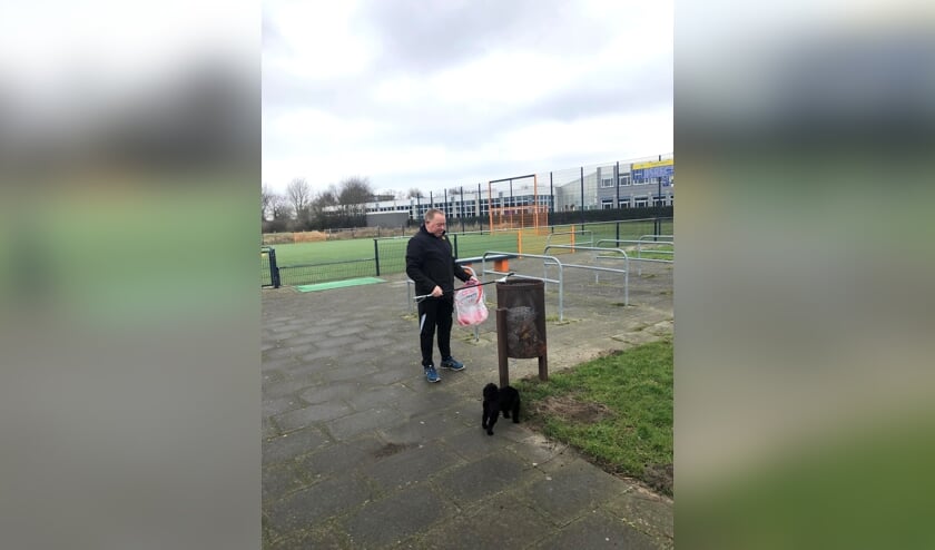 <p>Henk Schotanus laat zijn hondje Pip uit en ruimt meteen rommel op.</p>