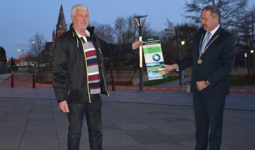 <p>Louis de Haan overhandigt Jeroen Weerdenburg de verzamelde 2.392 handtekeningen.</p>
