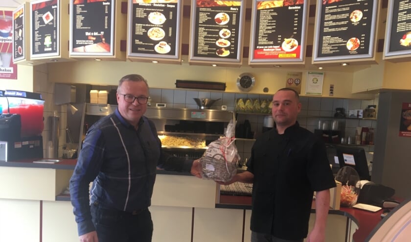 <p>David Querido (rechts) neemt het pakket in ontvangst.</p>