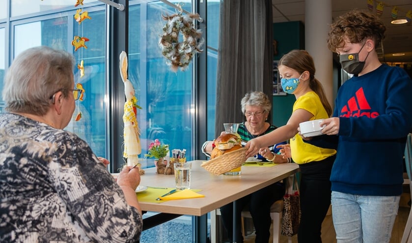 <p>Voor het fotomoment mogen twee leerlingen heel even de soep en broodjes uitserveren.</p>